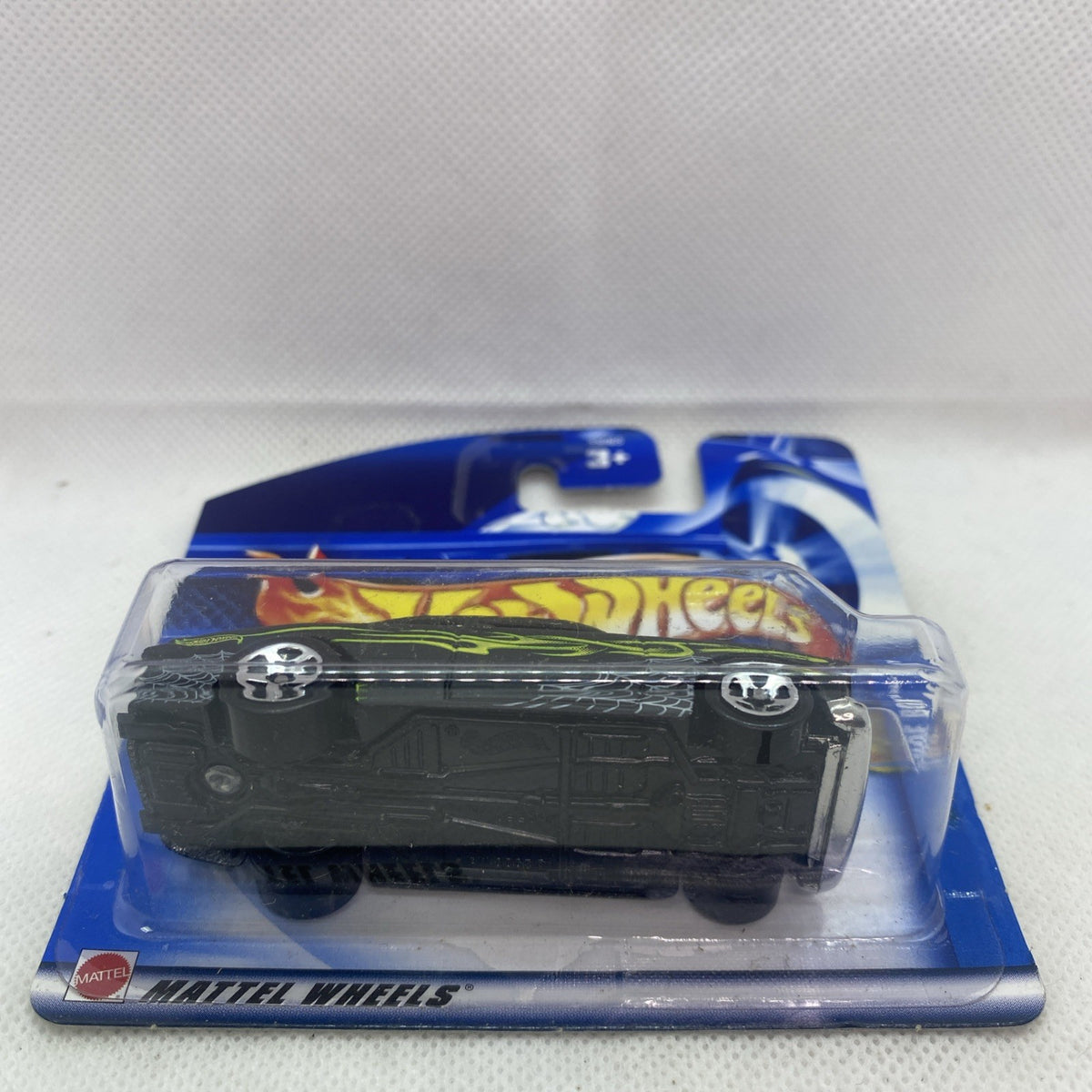 Hot Wheels die-cast car side view in blister, black with neon green flame stripe