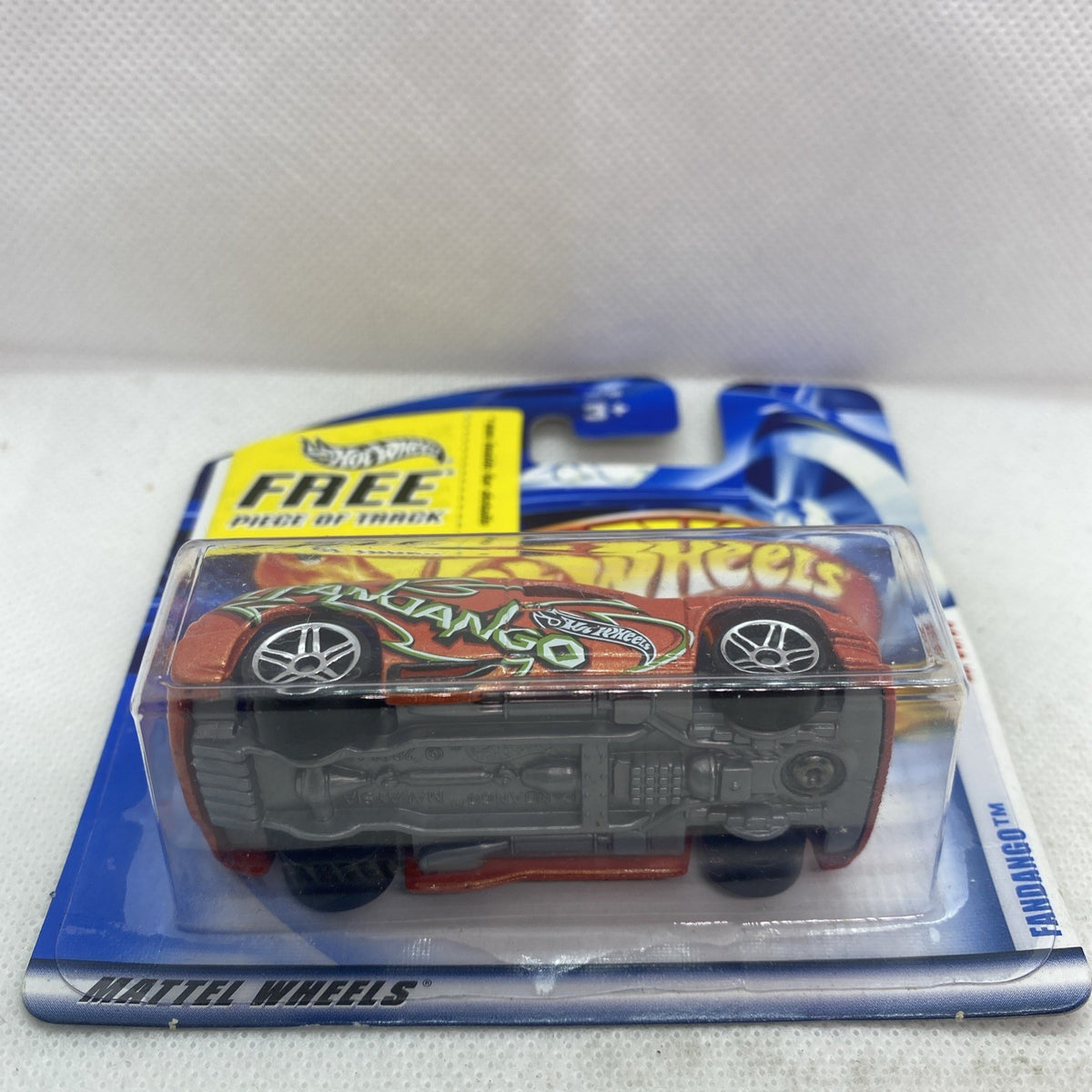 Hot Wheels die-cast car in blister, orange body with green graphics on blue card