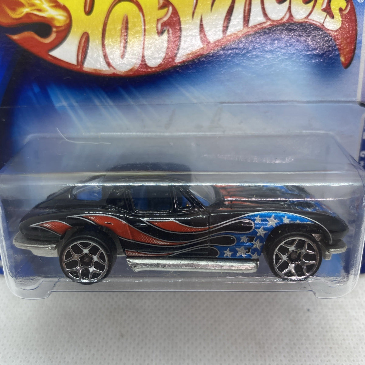 Hot Wheels Corvette die-cast side view in blister, blue-and-star graphics with orange flame stripe