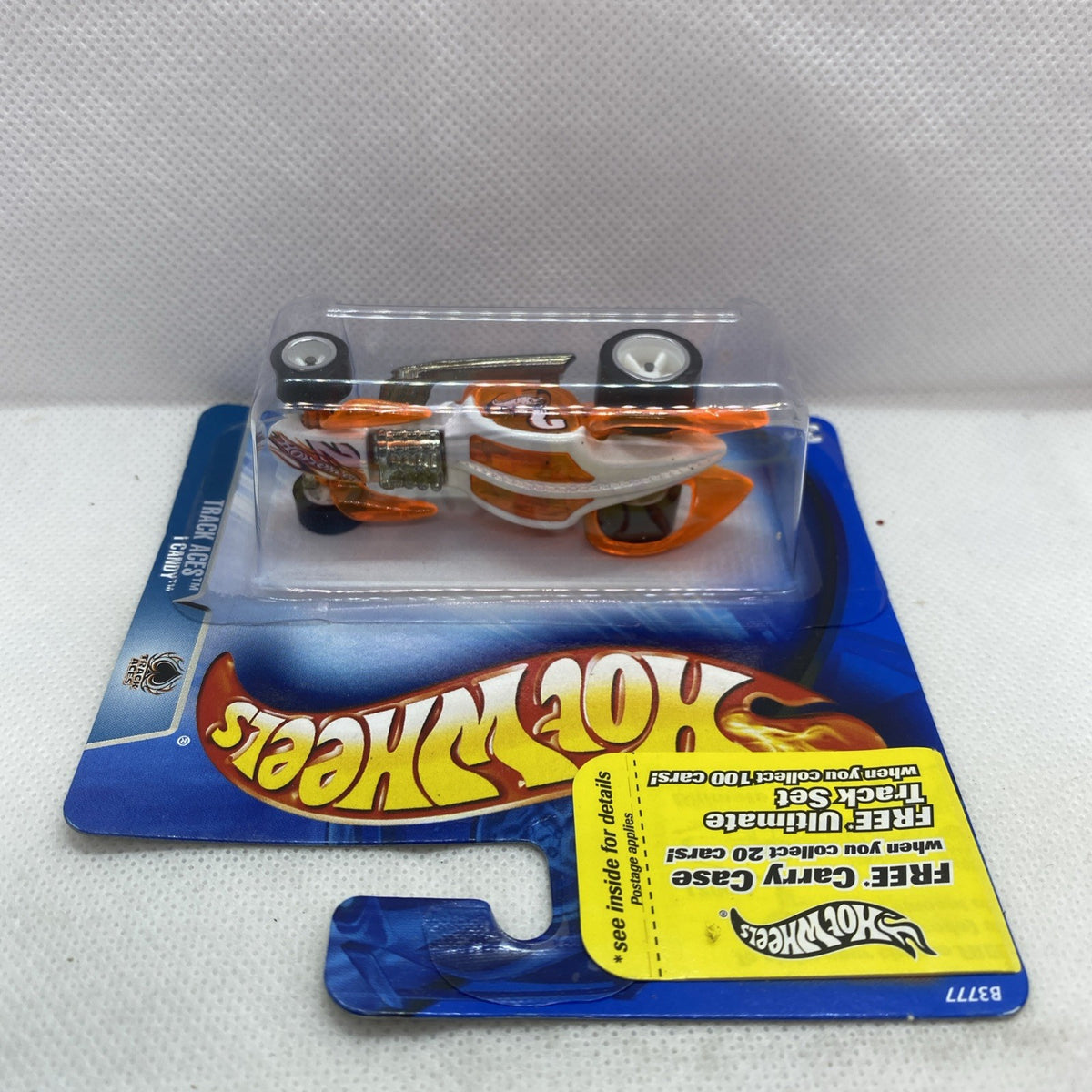 Hot Wheels orange race car toy in clear blister on blue card with yellow label