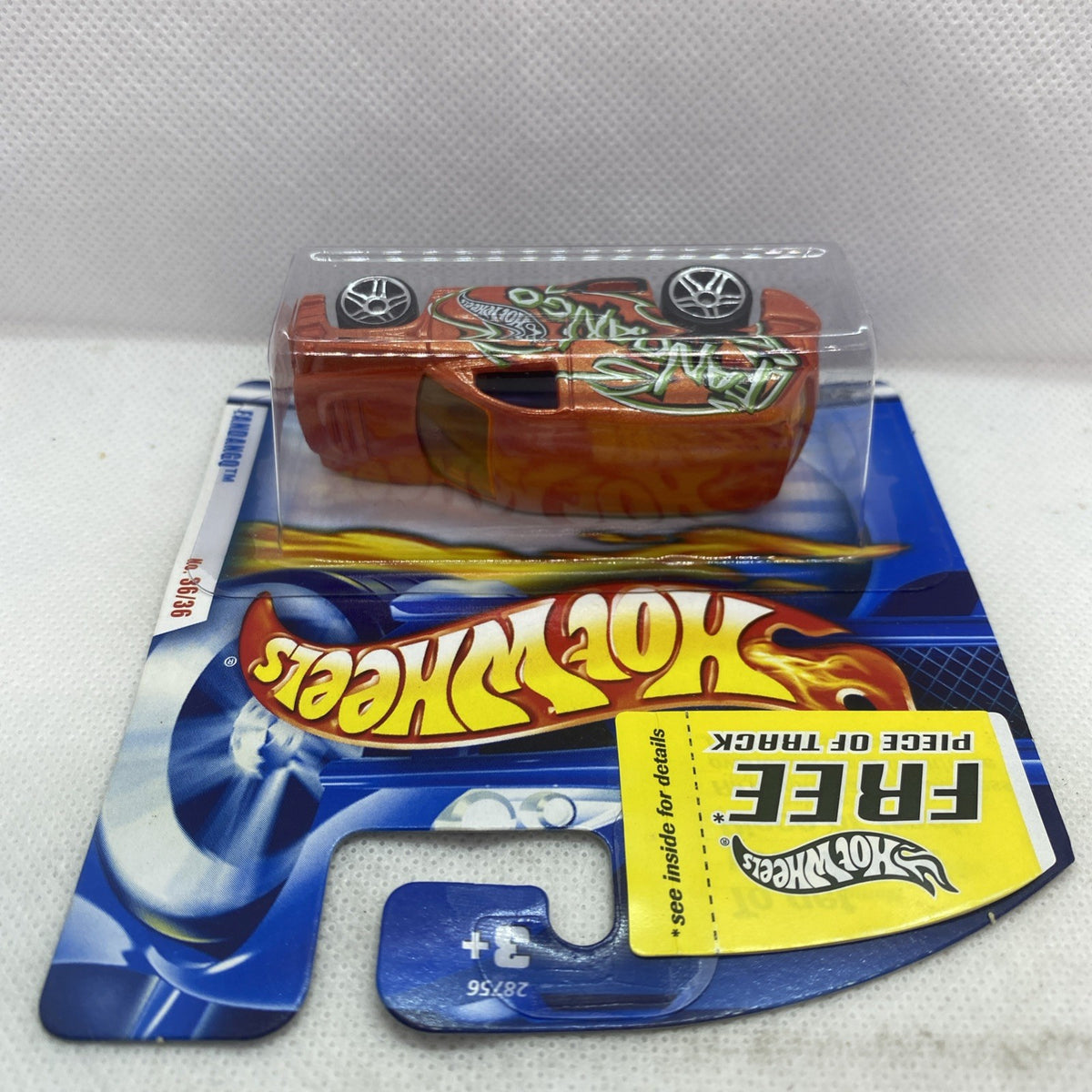 Hot Wheels die-cast car on card blister, orange body with green artwork and silver wheels