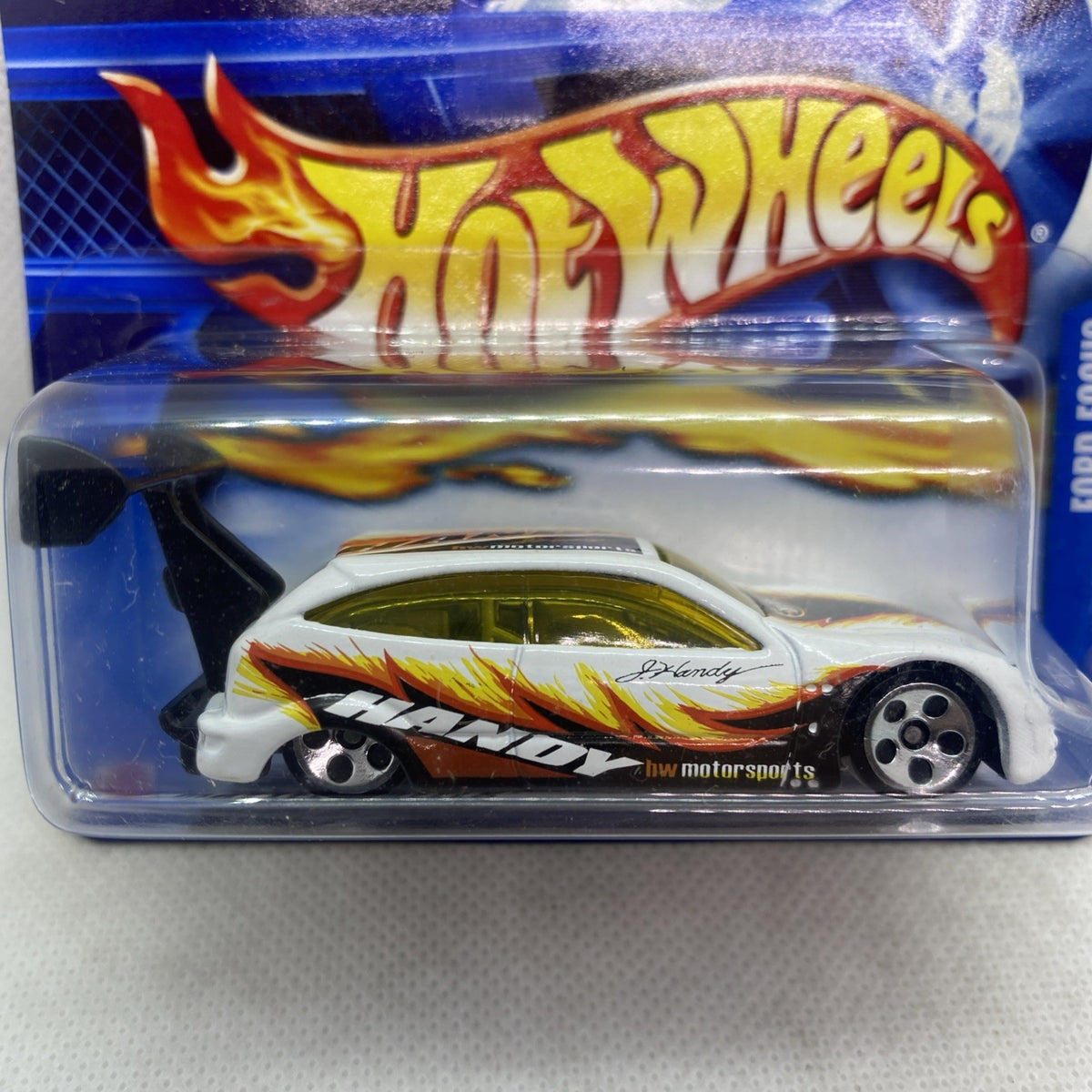 Hot Wheels Ford Focus die-cast car in blister pack, white with orange flame side art and wheels.