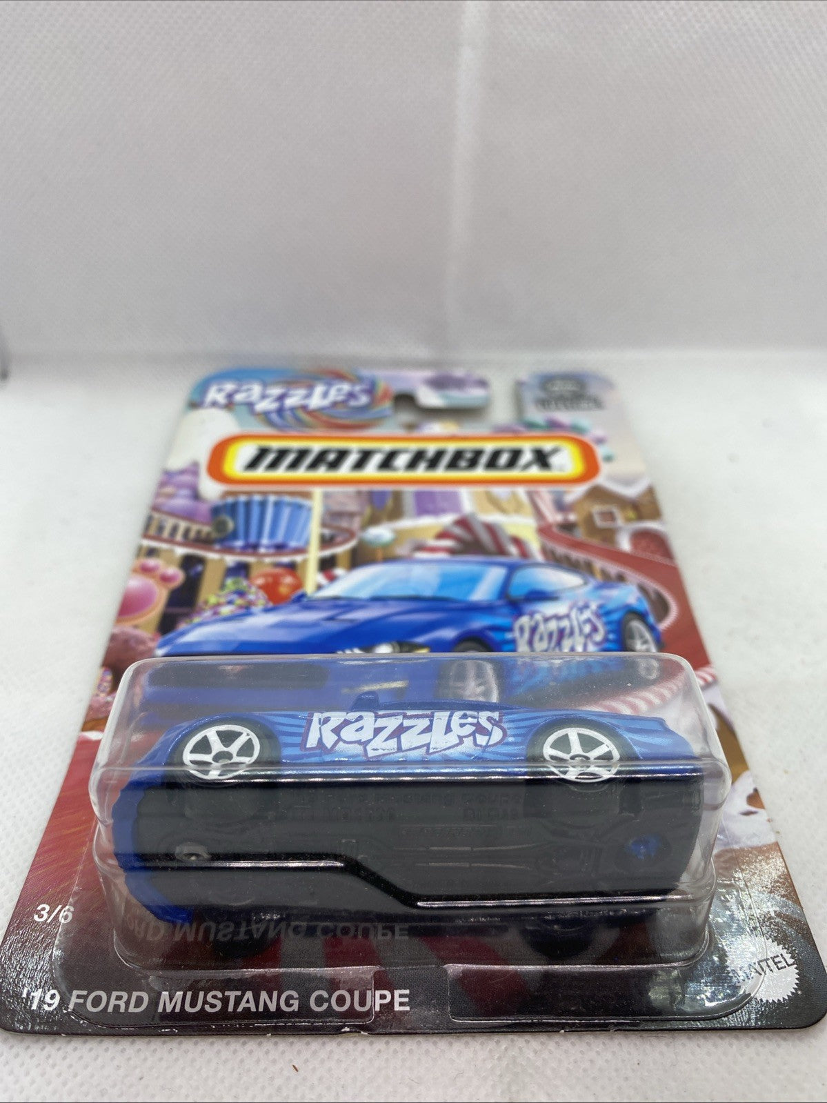 Matchbox toy car blister pack showing blue car with "Razzles" graphic on front