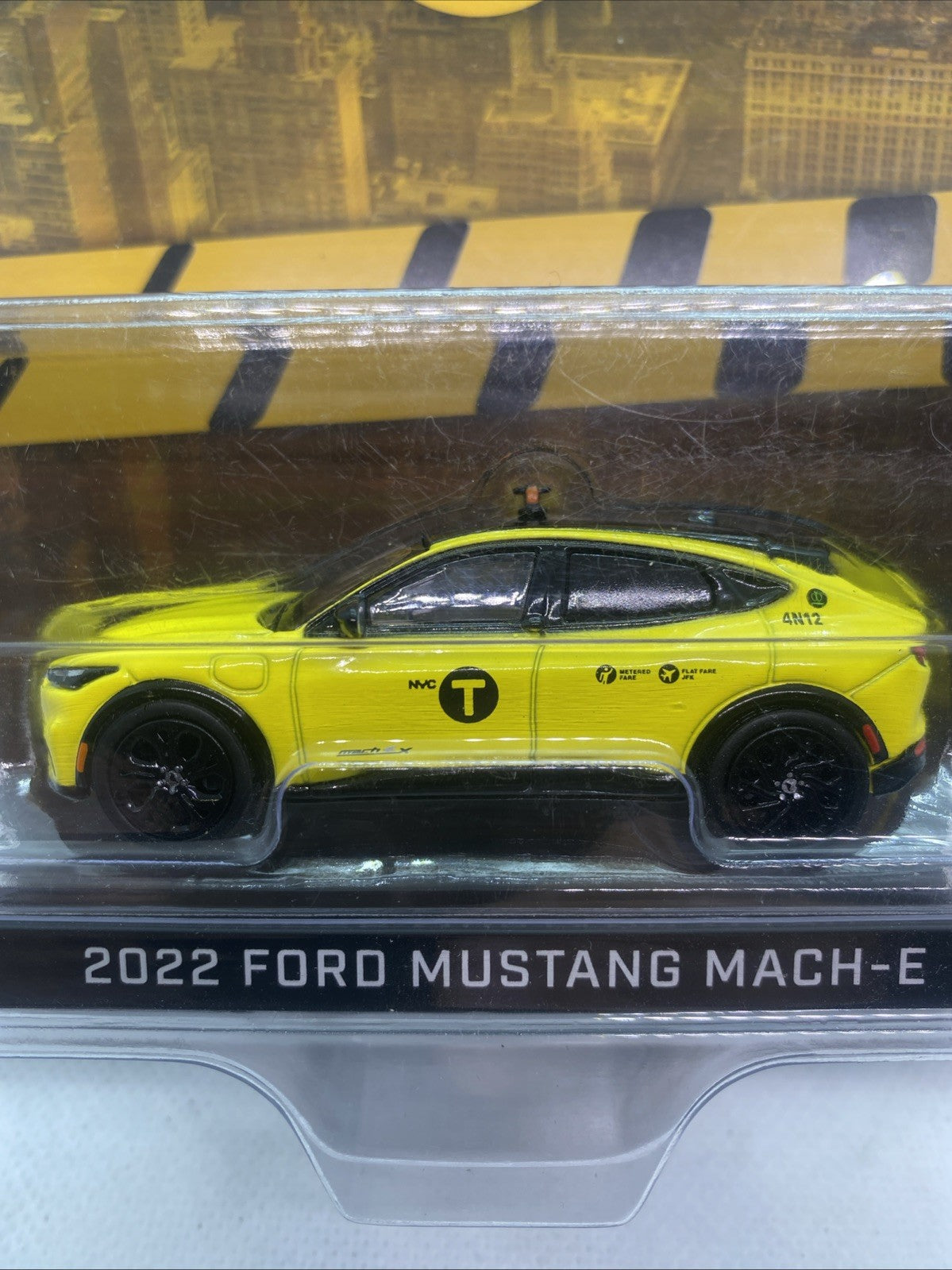 Yellow NYC Taxi die-cast car model side profile in clear blister.