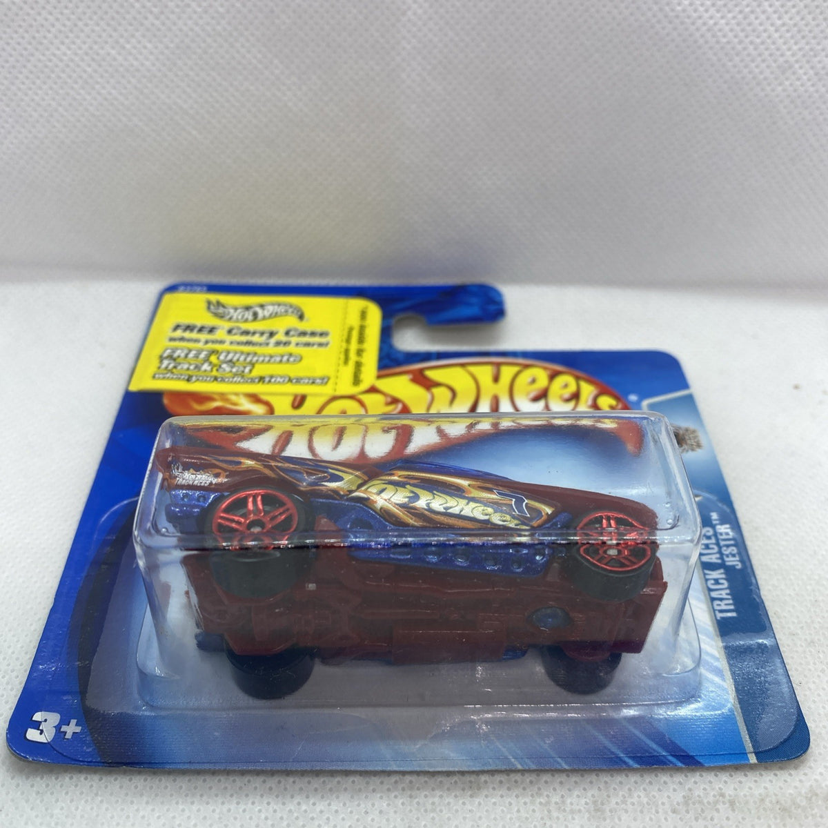 Hot Wheels maroon die-cast race car on blue blister card with flame graphics and red wheels.