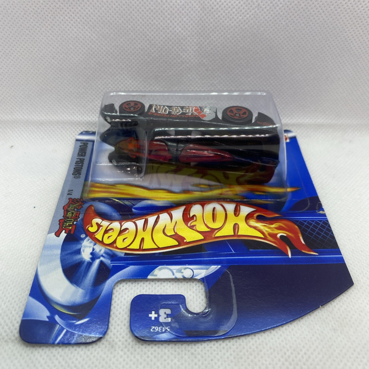 Hot Wheels blister card with packaged black and red die-cast car, side view.