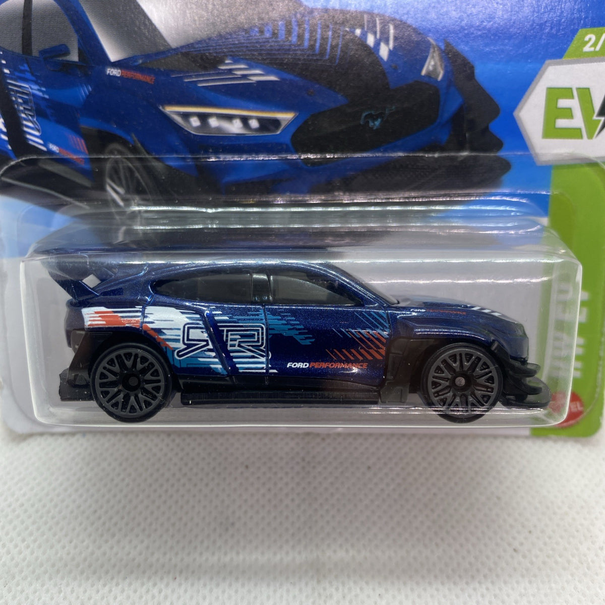 Blue and black Hot Wheels EV die-cast car close-up in clear blister