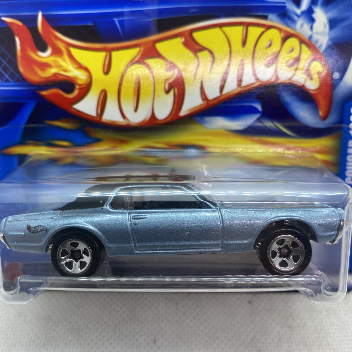 Hot Wheels ’68 Cougar die-cast in silver on blue blister card, side close-up