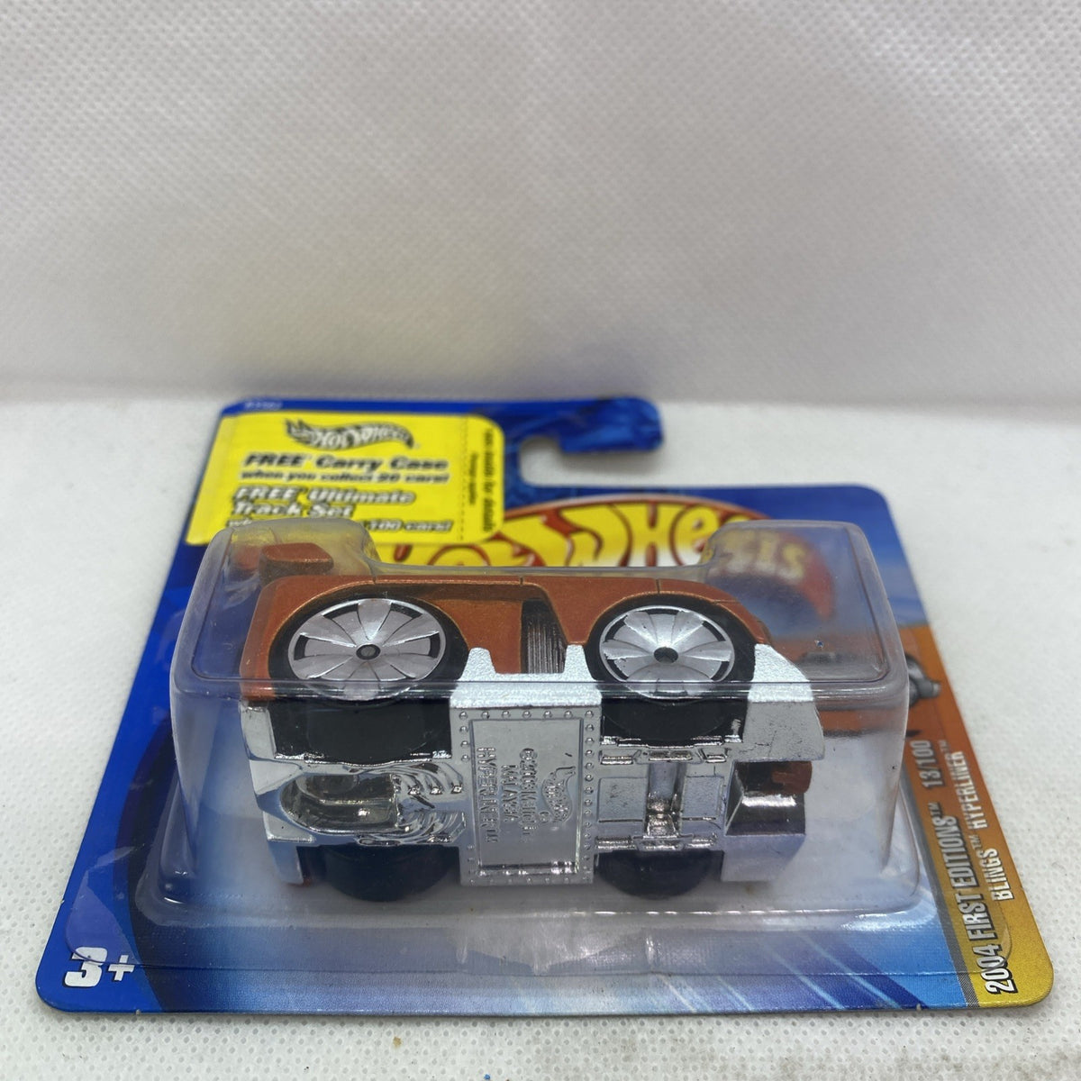 Hot Wheels die-cast car blister showing silver underside and two large wheels