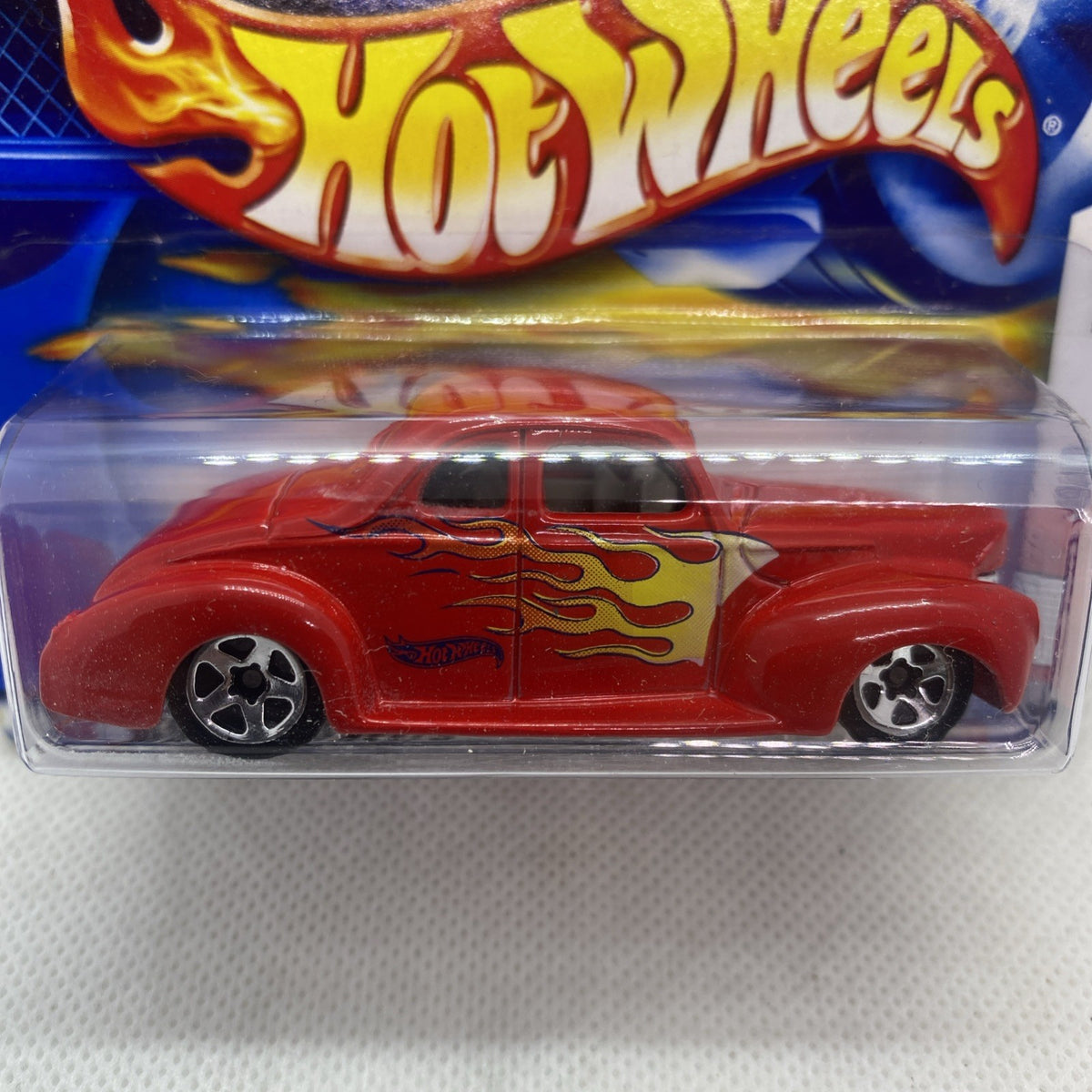 Hot Wheels red flame coupe toy car close-up in clear blister with chrome wheels