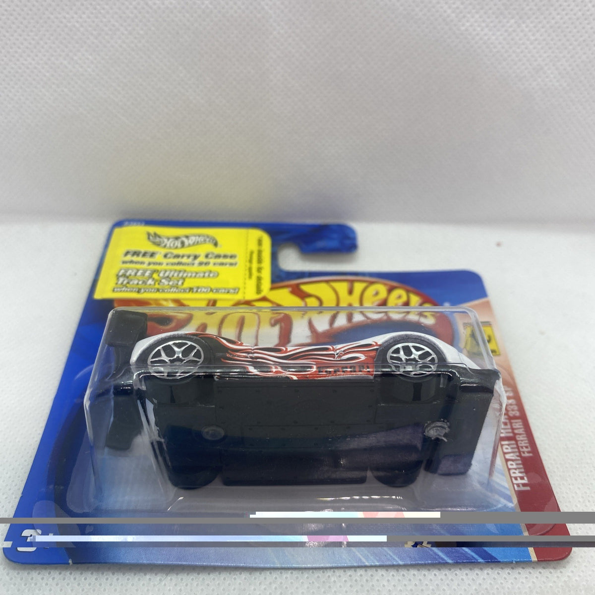 Blister pack front view of a white race car with red flame decals and black wheels