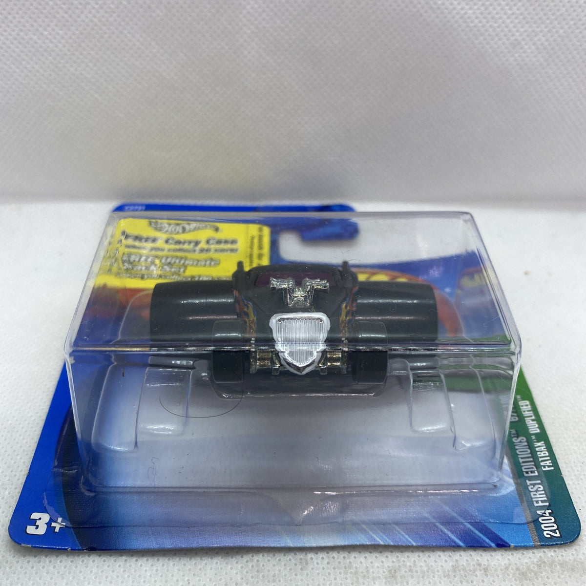 Hot Wheels die-cast car blister pack, front view with silver grille and purple accents