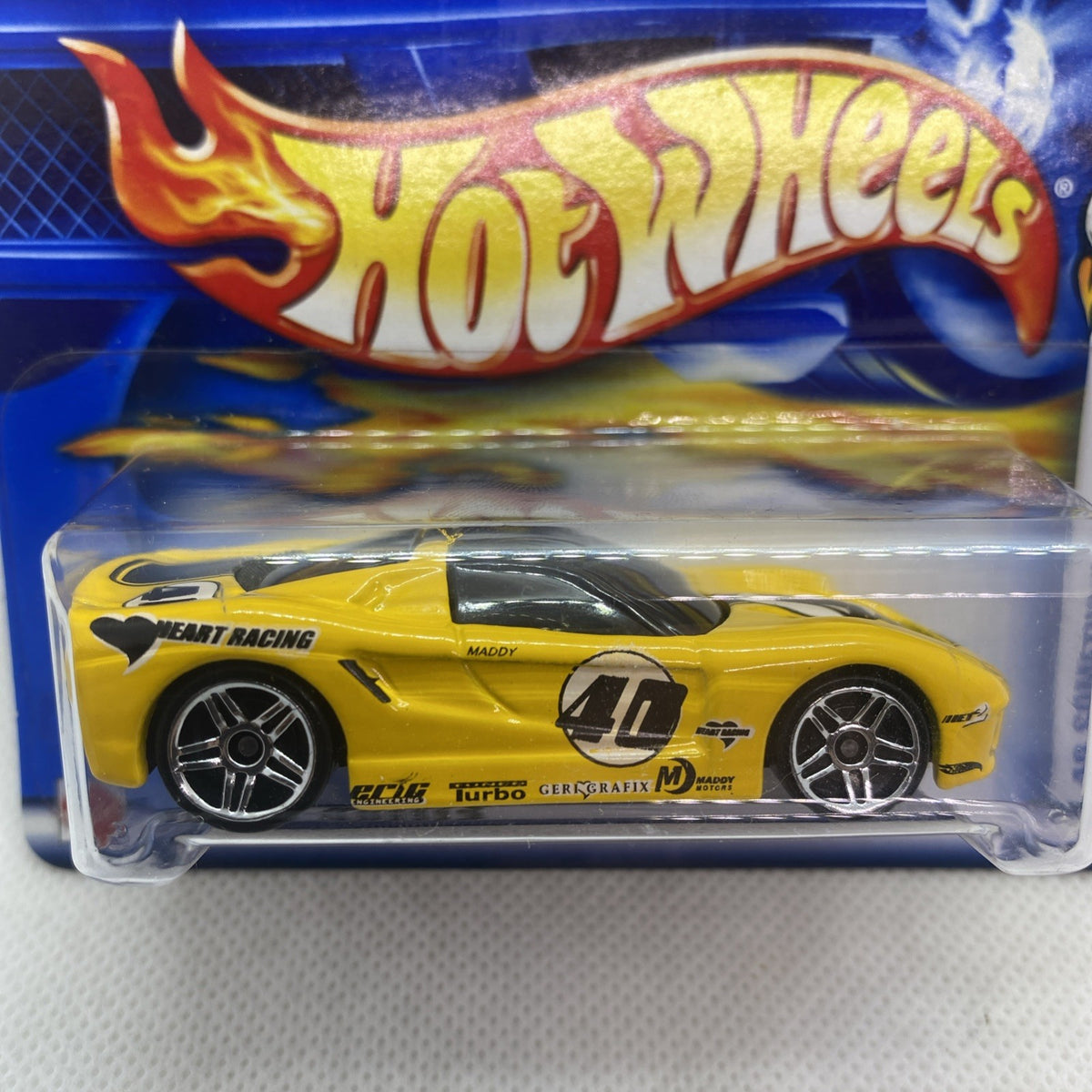 Sealed yellow racing car in blue Hot Wheels card with flame logo and blister window