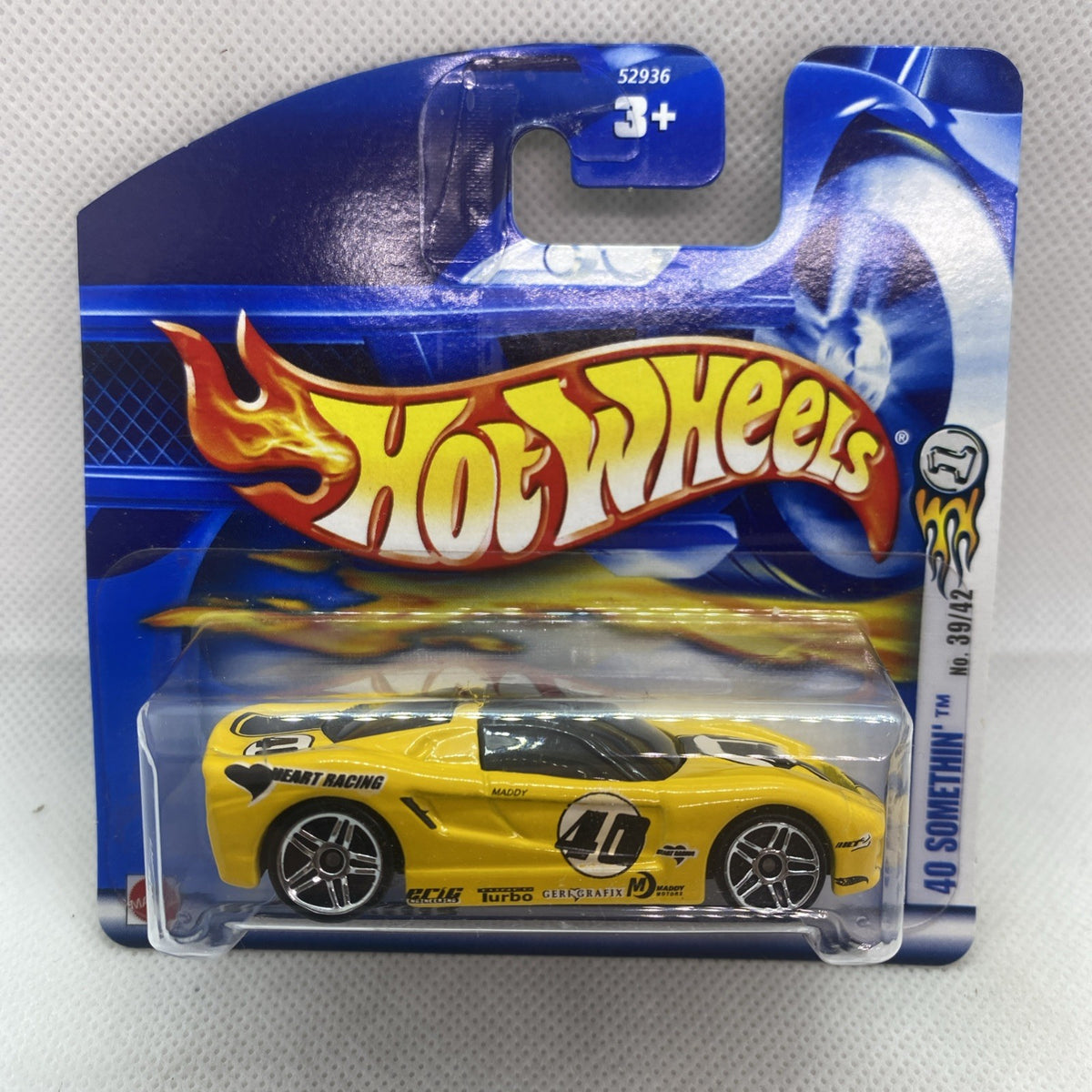 Sealed yellow die-cast car in blue Hot Wheels blister card, black wheels and racing decals
