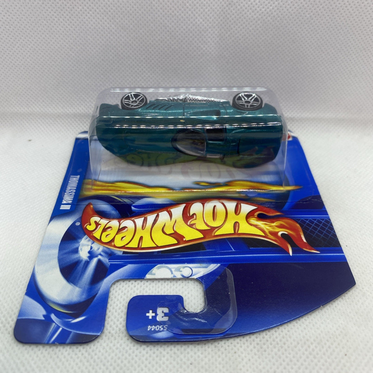 Hot Wheels die-cast car blister: dark green car, clear window, sealed