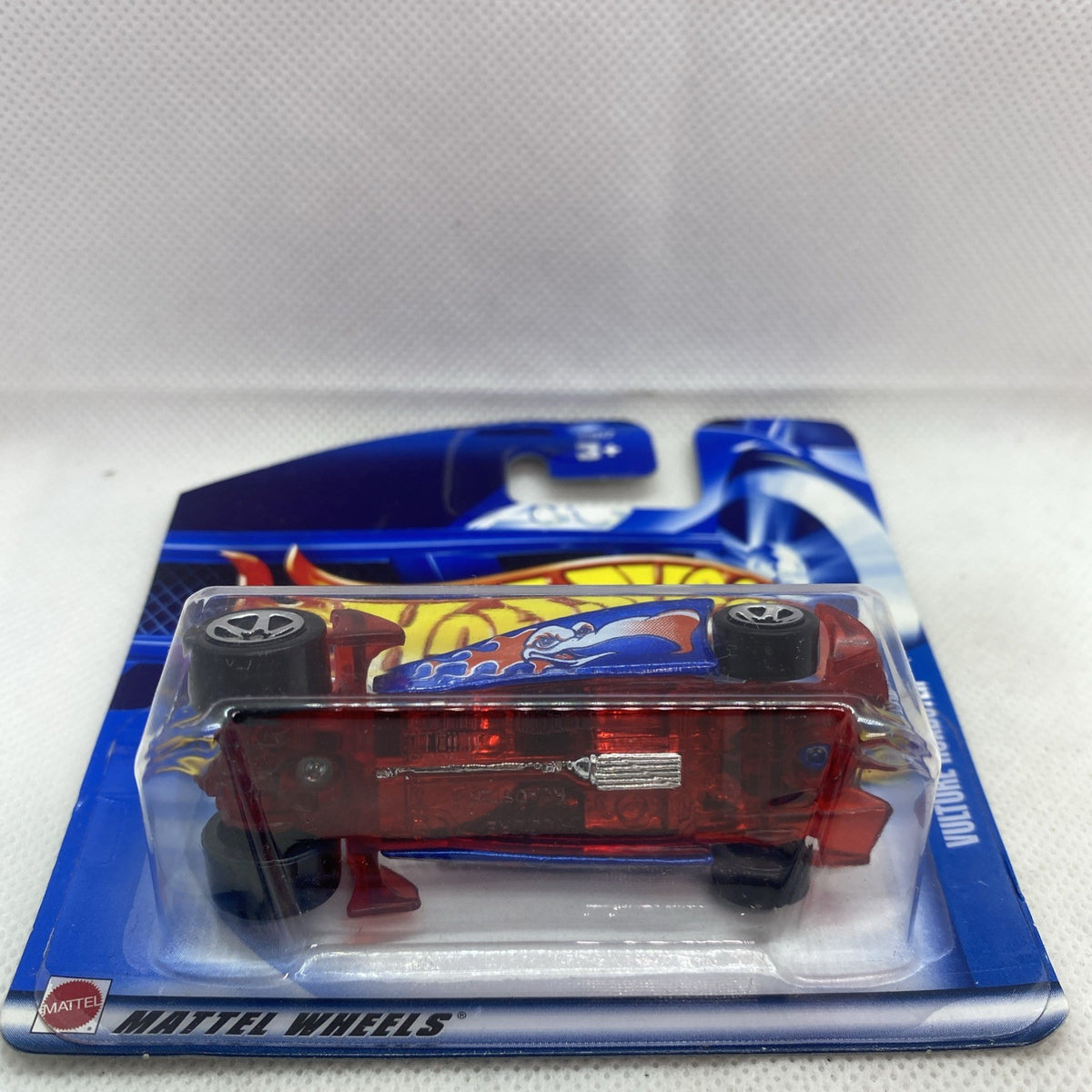 Die-cast car blister back view: underside with red body, black and silver wheels