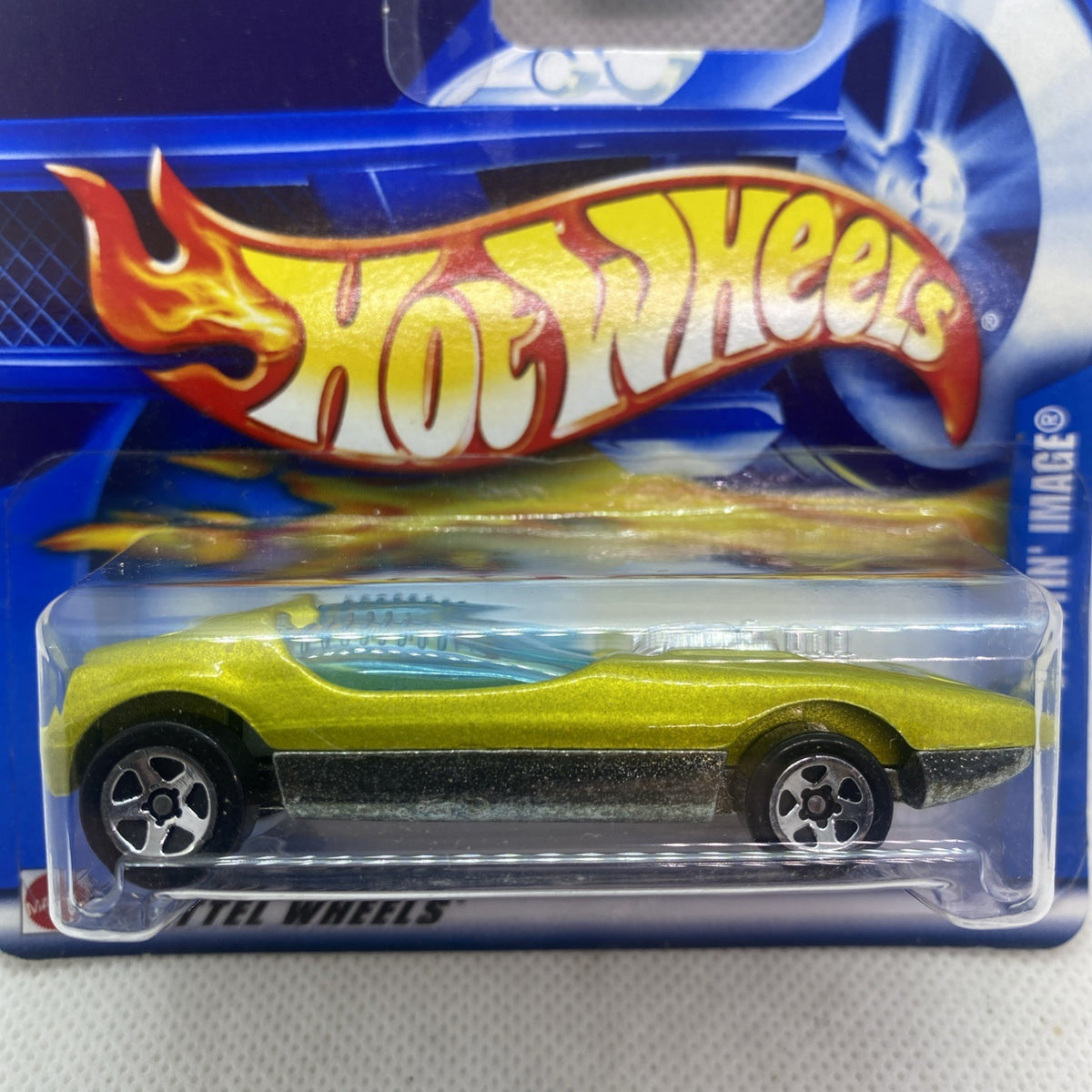 Green Hot Wheels die-cast car close-up in blue blister, flame decal side