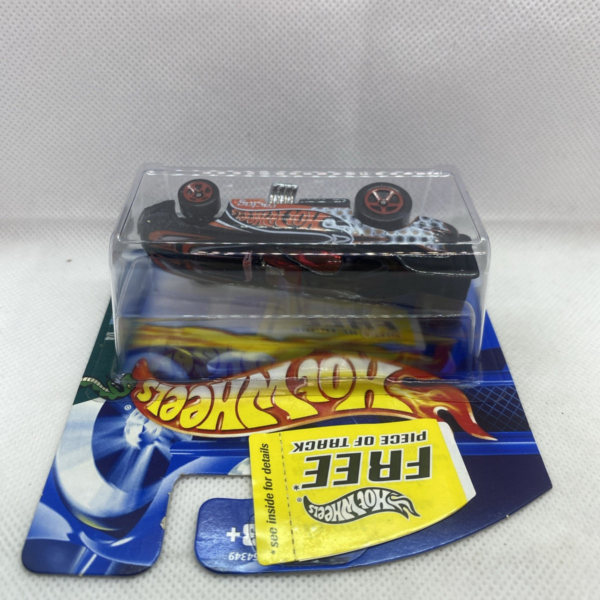 Hot Wheels Funny Car die-cast toy in clear blister, rear view, black with flame stripe.