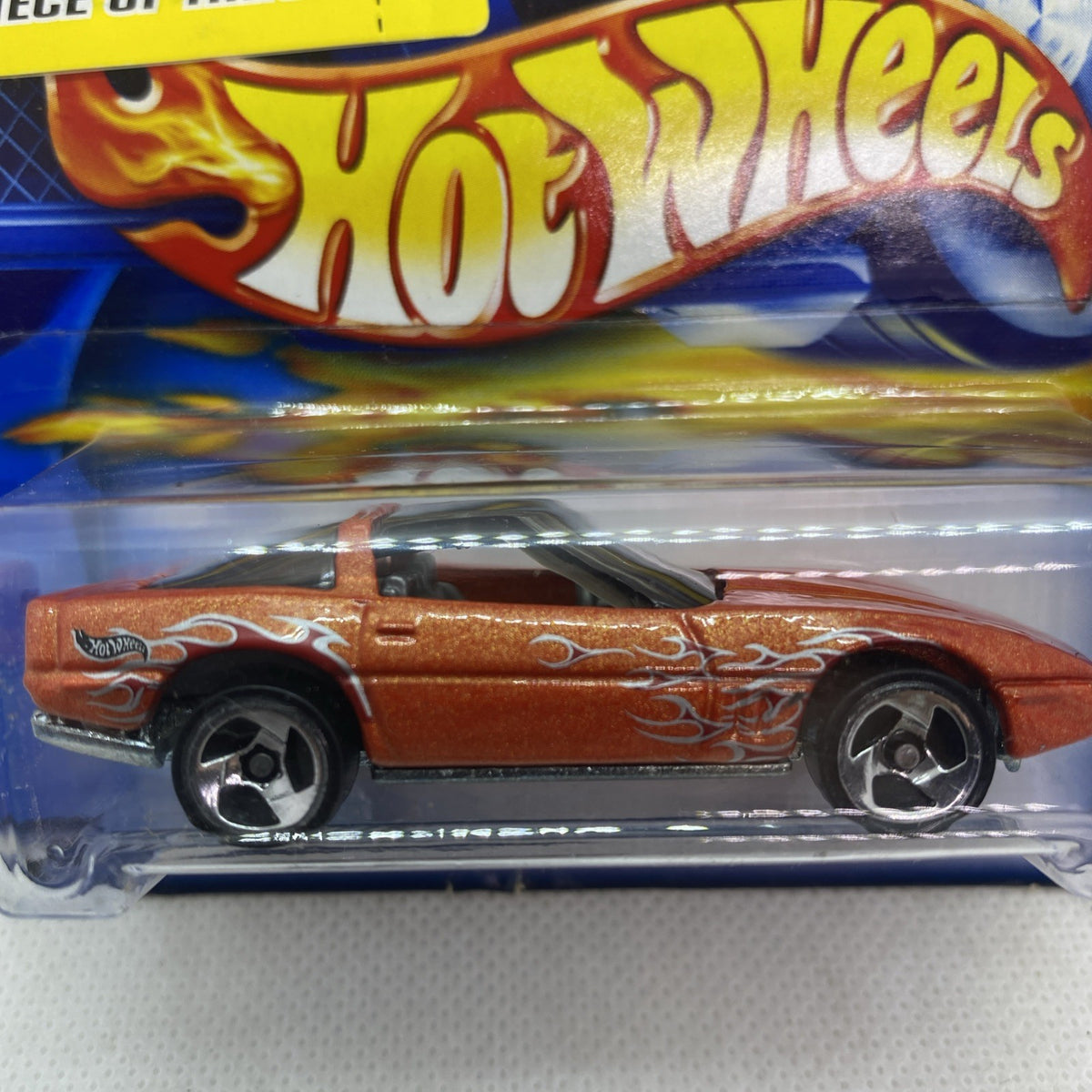 Orange die-cast Corvette toy car side view with flame decals in clear blister