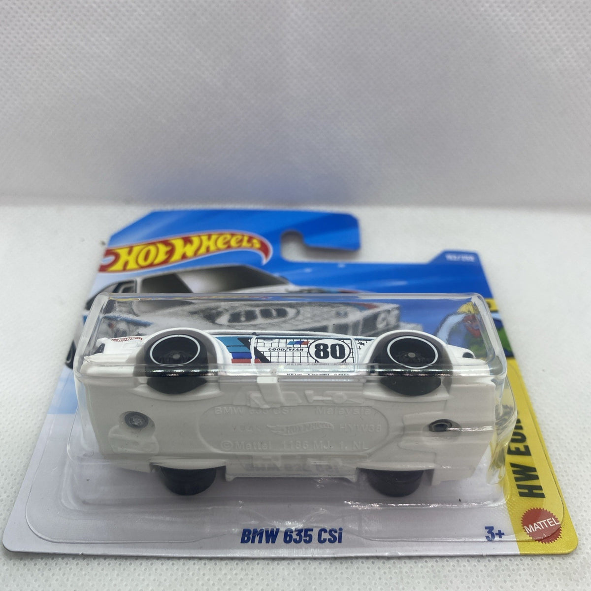 White die-cast car front view with blue stripe, headlights, in blister package