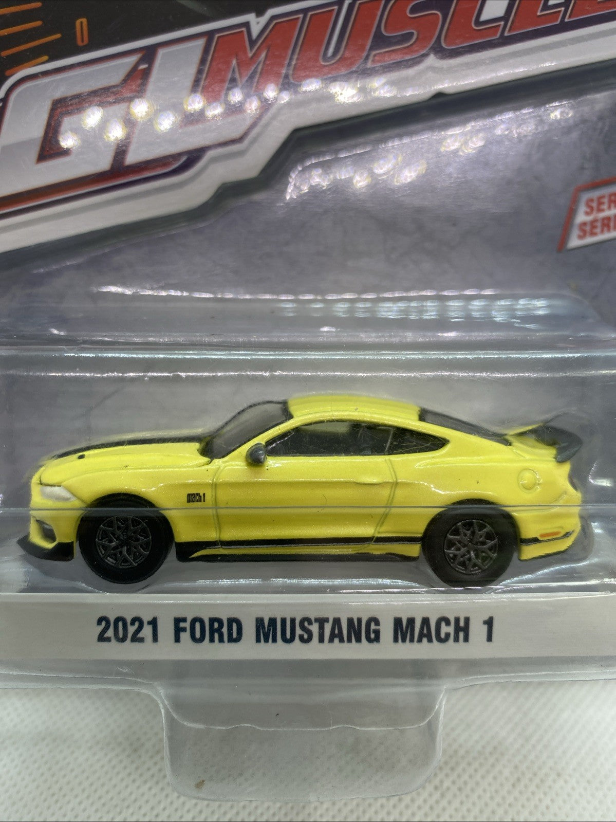 Yellow 1:64 2021 Ford Mustang Mach 1 die-cast car close-up in clear blister