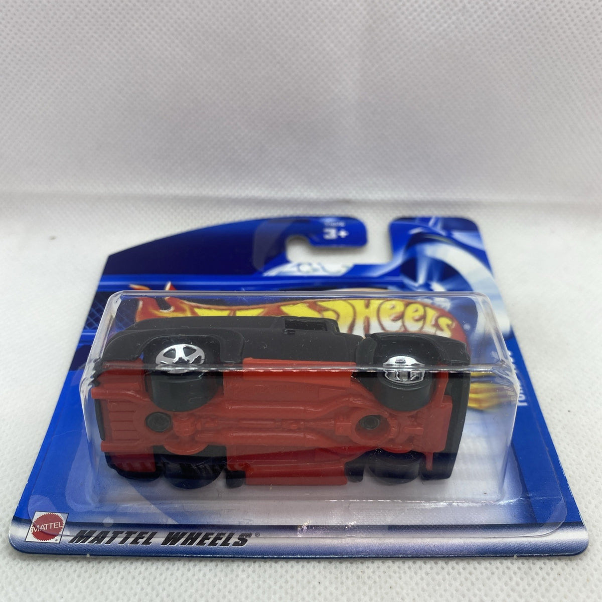 Hot Wheels die-cast truck in blister, side/front view, brown-red body with black base